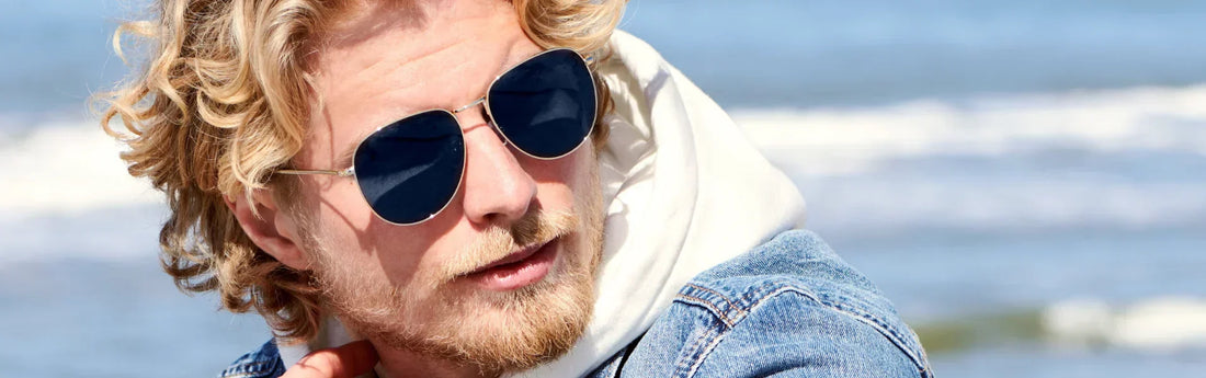 Hombre con gafas de sol tipo aviador con el mar de fondo