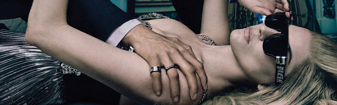 Mujer con gafas Phillip Plein posando para una foto con las manos de un hombre en sus hombros