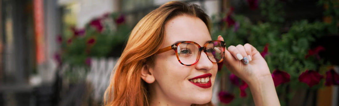 Mujer sonriendo con cabello castaño claro y gafas graduadas de pasta